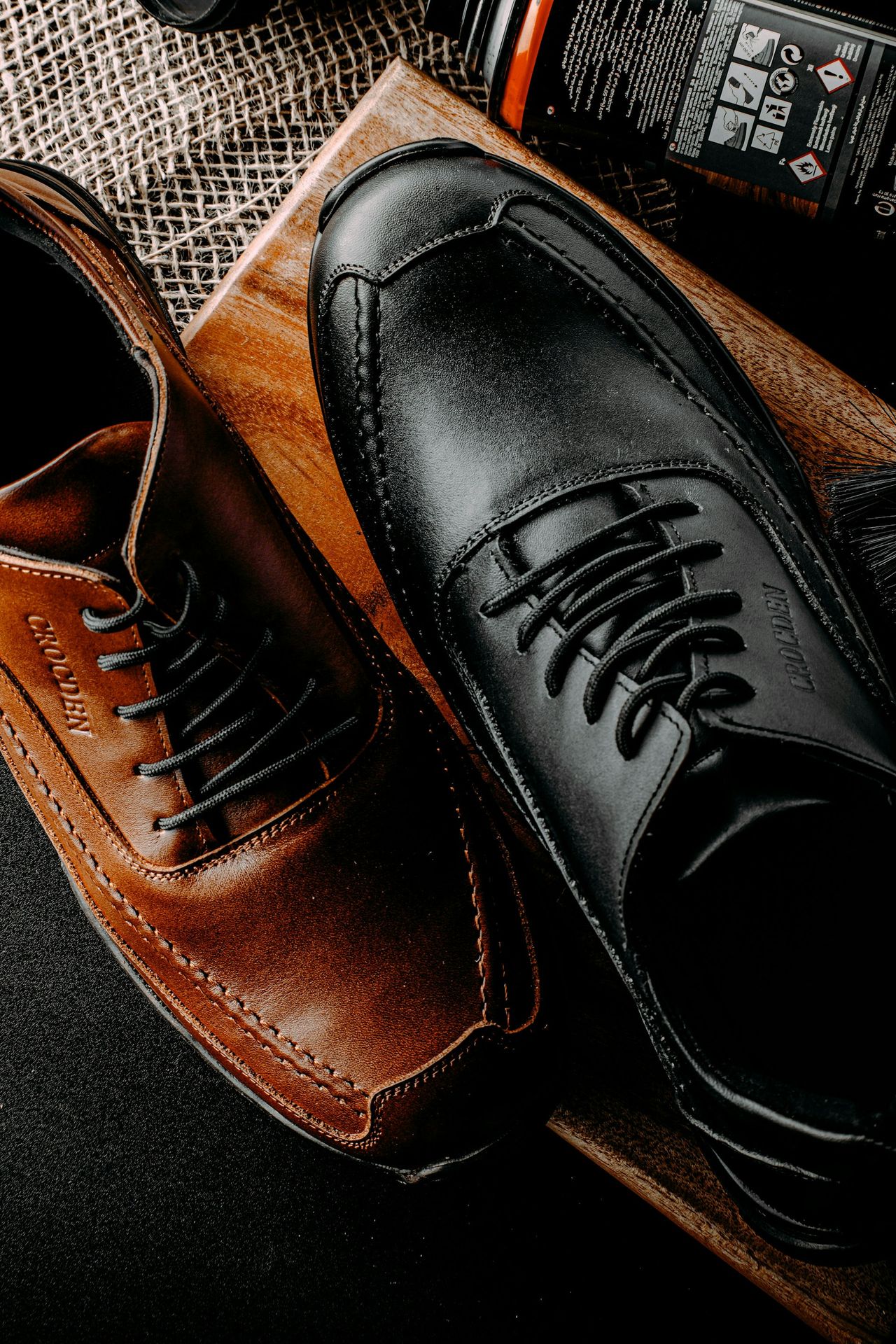a pair of black and brown shoes sitting on top of a table
